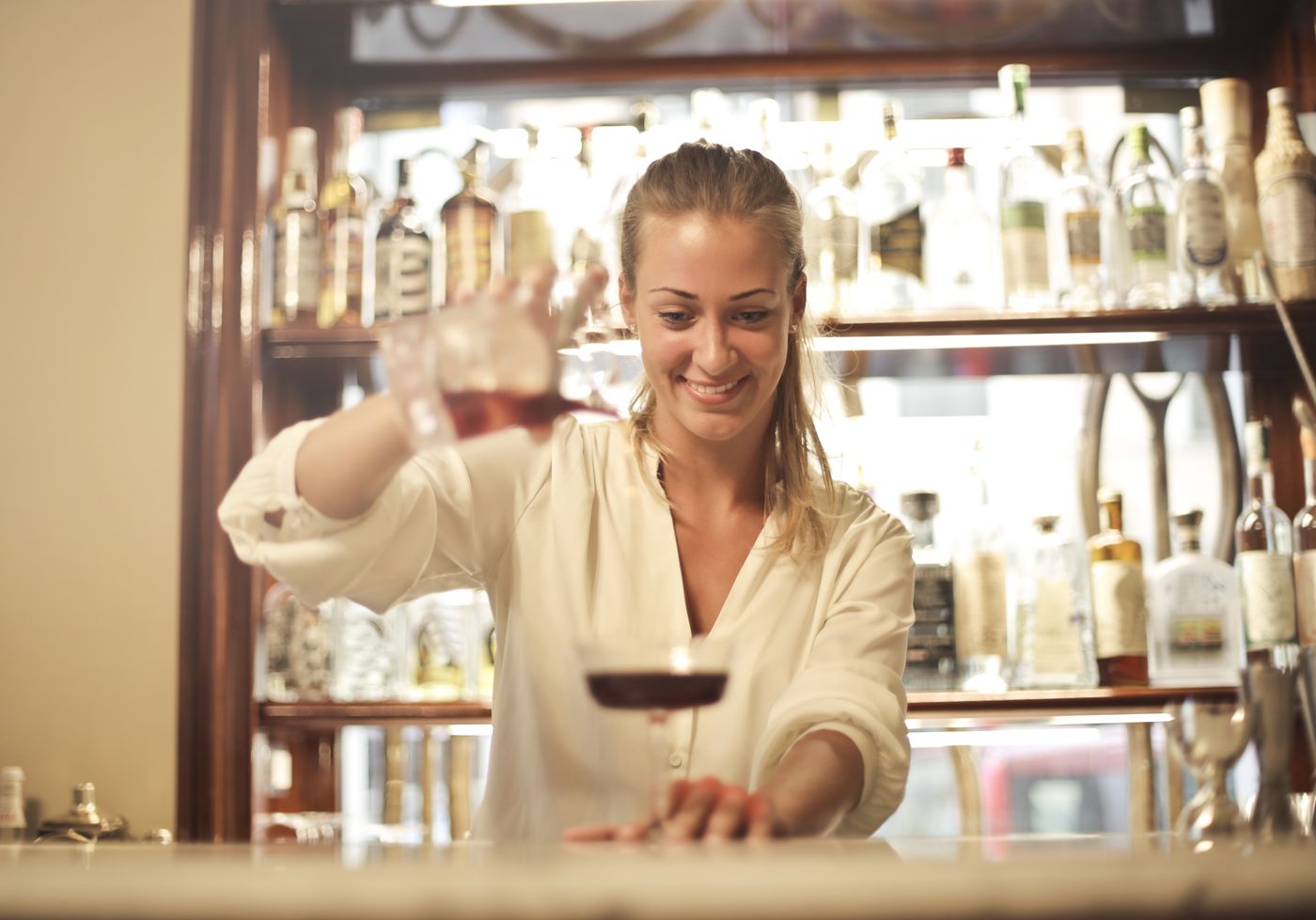 Dueña de un bar atendiendo el mostrador con una sonrisa